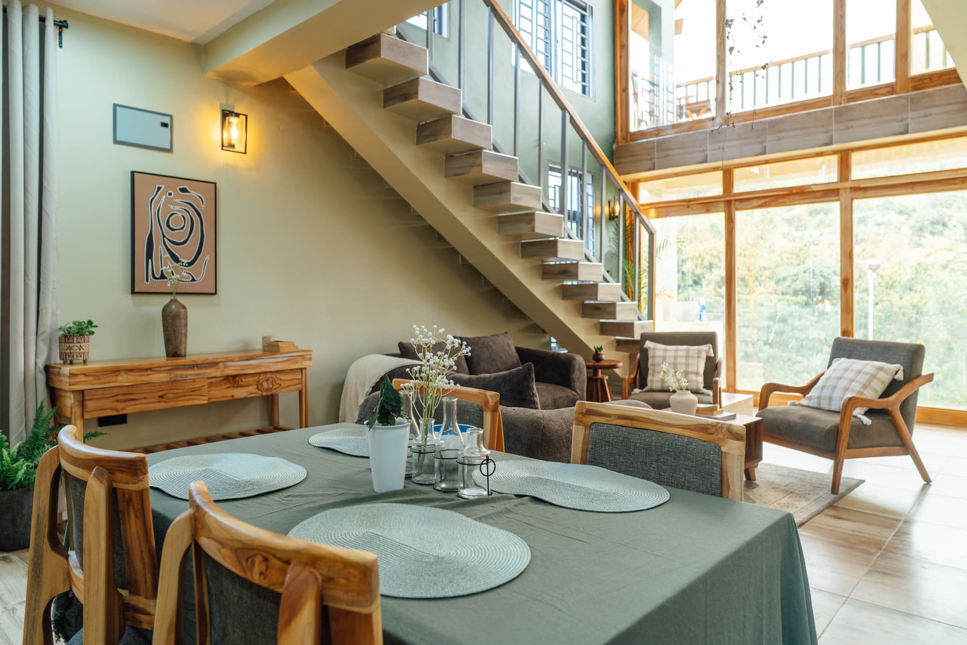 Dining table, living room, and staircase in a Starico Residence loft apartment